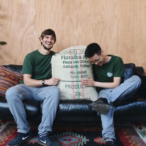 
                  
                    Load image into Gallery viewer, Made of Many Team holding a bag of bean coffee 
                  
                