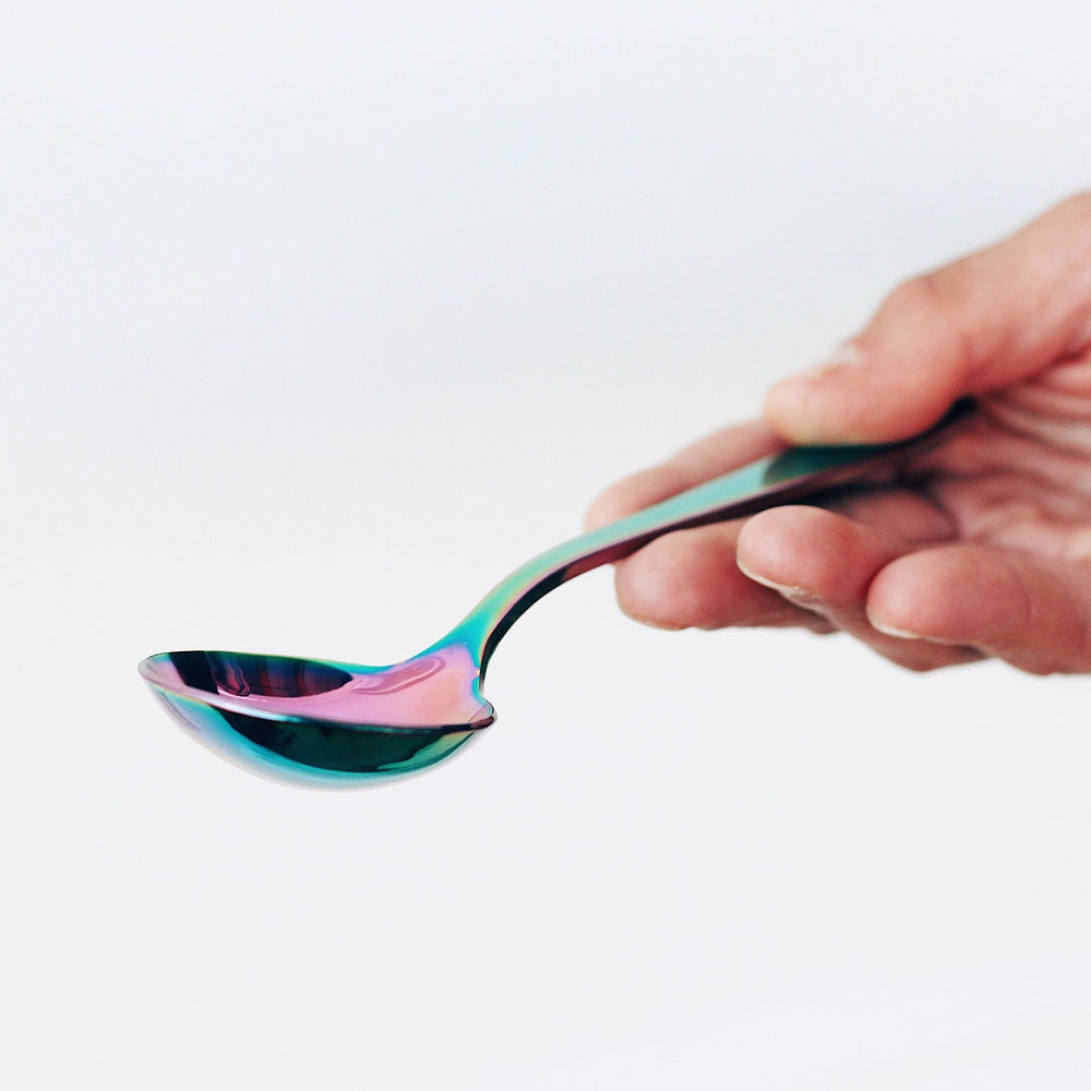 
                  
                    Load image into Gallery viewer, Holding a Umeshiso Little Dipper cupping spoon in Rainbow
                  
                